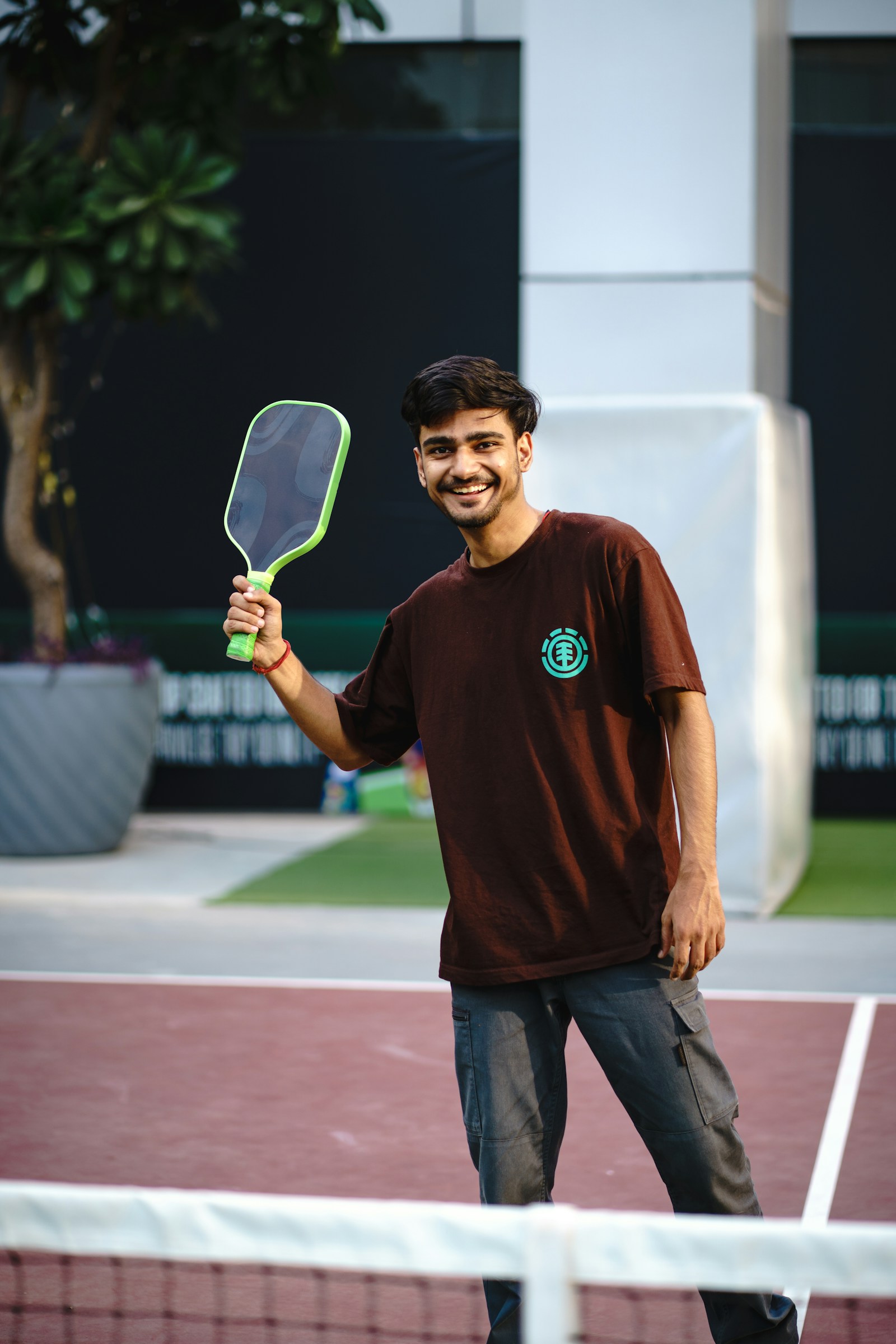 Smiling pickleball player holding a paddle on an outdoor court