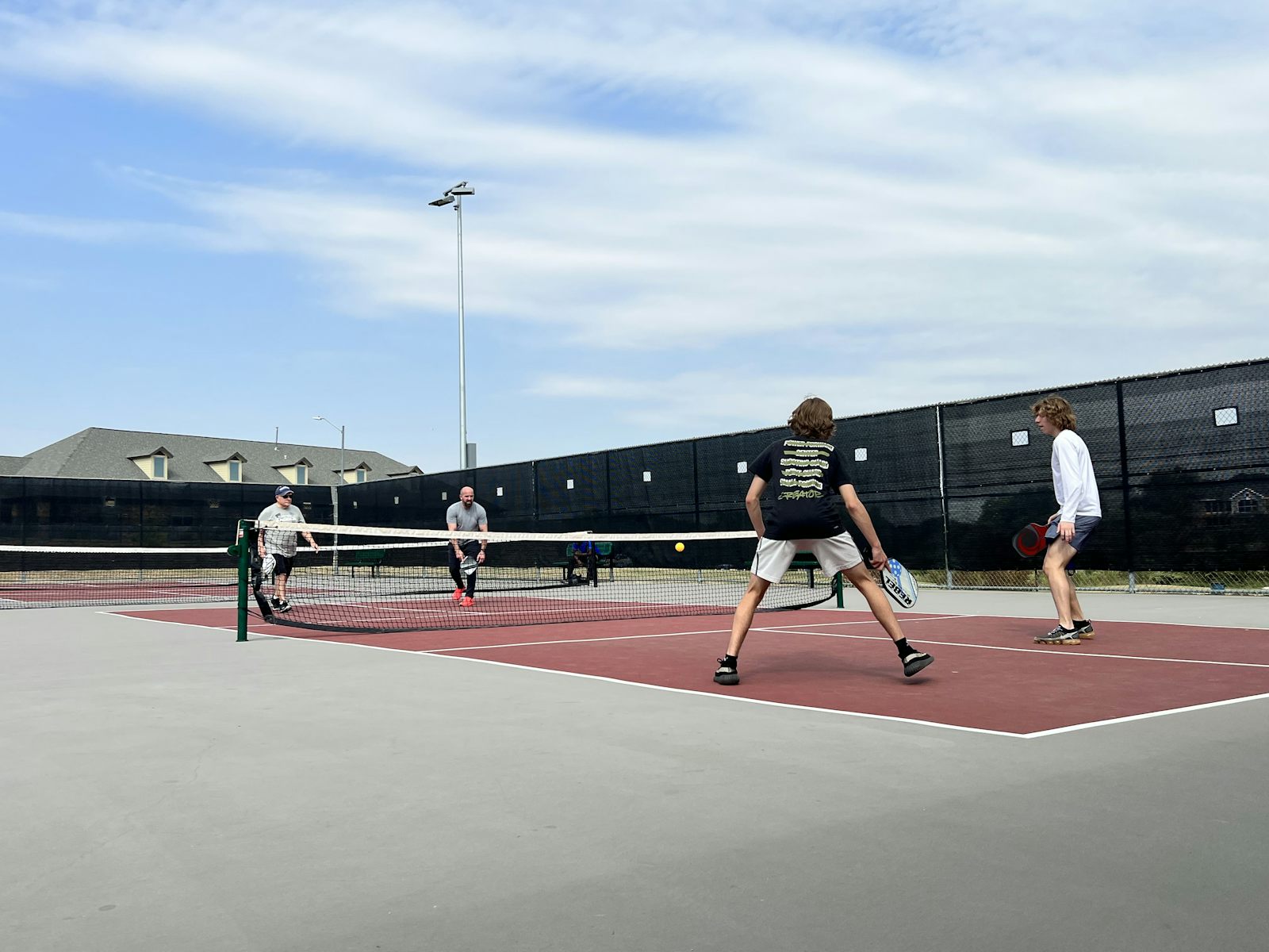 A group of pickleball players gathered on the court — community is at the heart of pickleball etiquette