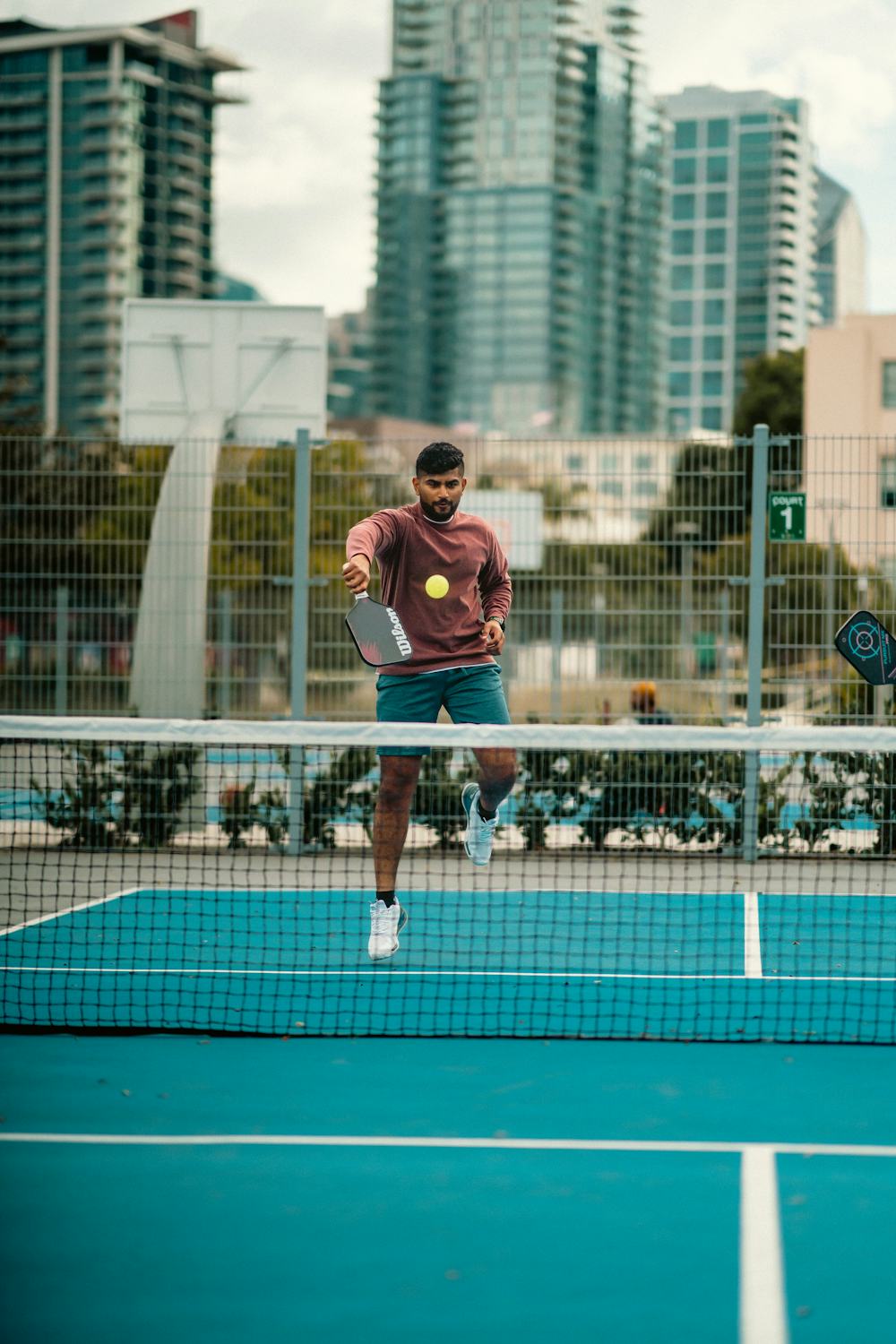 A pickleball player set up at the kitchen line in ready stance